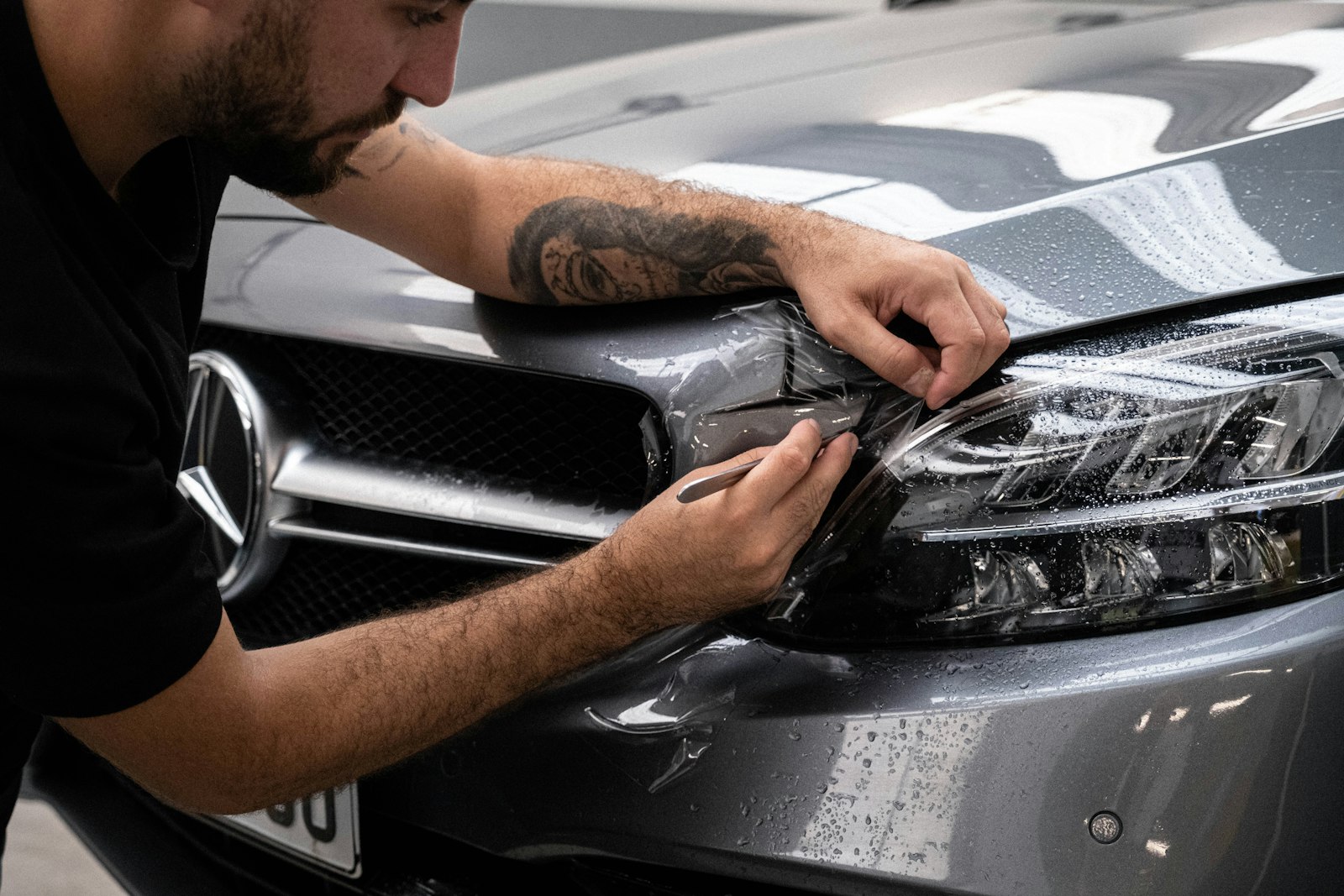 Detailer applying paint protection film to the front of a Mercedes-Benz